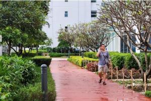 a woman walking down a path in a park at Boho Beach Vibes 2br Apt 2 in Makati in Manila
