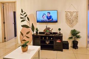 a living room with a flat screen tv on the wall at Boho Beach Vibes 2br Apt 2 in Makati in Manila