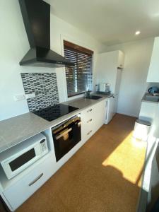 a kitchen with a sink and a stove top oven at Sea-Renity Picton, Apt A in Picton +5 photos