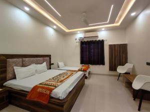 a bedroom with a bed and a table and chairs at BRiJWAS DHAM in Vrindāvan