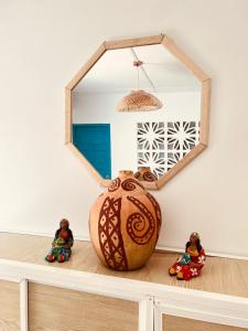 a mirror sitting on top of a shelf with dolls at La Casita De Emma in Ríohacha