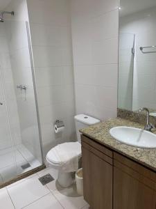 a bathroom with a shower and a toilet and a sink at Flat Particular Marizienne Hotel Saint Moritz 31 in Torto