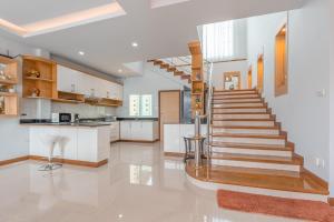 a staircase in a kitchen with white walls and wooden floors at Sunflower Pool Villa Central Pattya in Pattaya South