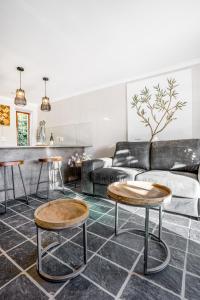 sala de estar con 2 mesas y sofá en Avemore Time Out - full power back up, en Stellenbosch