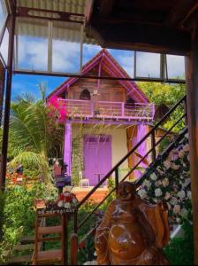 ein Haus mit einer lila Tür davor in der Unterkunft homestay nhà sàn in Buôn Alê (1)