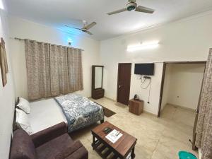 a living room with a bed and a couch at KRISHNAM GUEST HOUSE in Gwalior