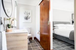 a bathroom with a bed and a sink and a toilet at Avemore Orchard Le Verger in Stellenbosch +22 photos