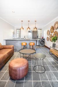 a living room with a couch and a table and chairs at Avemore Orchard Apartment - with full Backup power in Stellenbosch