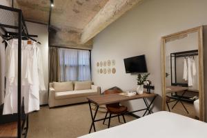 une chambre avec un lit, un canapé et un miroir dans l'établissement Anise, Aluma Hotels & Resorts, à Athènes