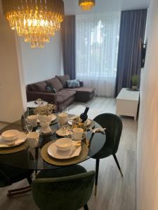 a dining room with a table and green chairs at Chic Residence apartament 3 in Šiauliai