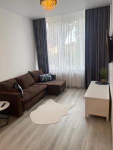 a living room with a couch and a table at Chic Residence apartament 3 in Šiauliai