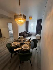 a living room with a dining room table and chairs at Chic Residence apartament 3 in Šiauliai