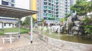 a fountain in the middle of a park with a table at Homestay Vista Alam in Shah Alam