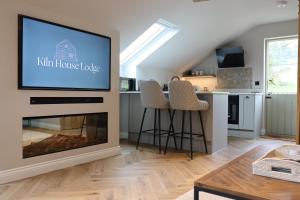 a living room with a fireplace and a flat screen tv at Kiln House Lodge in Harrogate