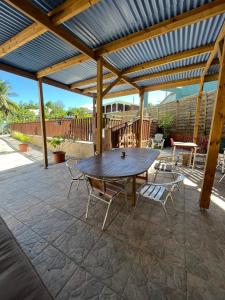 une table et des chaises en bois sur une terrasse dans l'établissement Vacances chez HélèneB, à Sainte-Anne