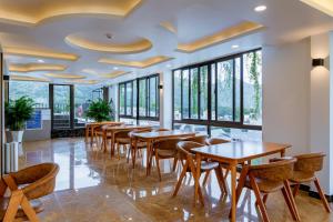 a row of tables and chairs in a restaurant with windows at Tuấn Ninh Hotel II in Con Dao