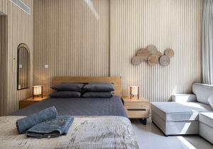 Un dormitorio con una cama grande y una silla. en Apartment With Private Garden - Luxe Gold, en Sharjah
