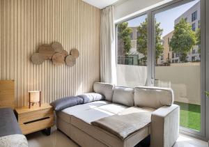 Una sala de estar con un sofá y una ventana grande. en Apartment With Private Garden - Luxe Gold, en Sharjah 78 fotos más