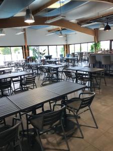 an empty cafeteria with wooden tables and chairs at Mobil home 6 personnes dans camping 5* in Houlgate