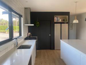 a kitchen with white counters and a sink and a window at Brooklyn Views in Feilding +16 photos