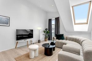 a white living room with a couch and a tv at Luxury penthous - 3 BR - 2 Bath - FreeParking - Downtown in Reykjavík