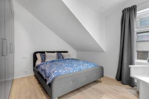 a bed in a white room with a window at Luxury penthous - 3 BR - 2 Bath - FreeParking - Downtown in Reykjavík