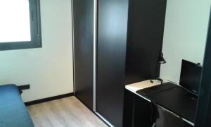 a room with a black partition with a desk and a television at Residencia Mayol - Adults Only in Palma de Mallorca