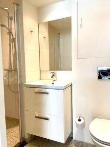 a white bathroom with a sink and a mirror at Apartment close to campus in Nijmegen +44 photos