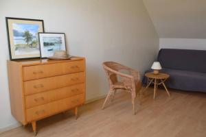 a bedroom with a dresser and a bed and a chair at Gîte rural LES VAUX CHEZ GERARD in Chaumont-sur-Loire