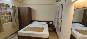 德瓦尔卡Hotel TGP The Grand Praatap的有两张床和一扇窗户的小房间