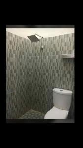 a bathroom with a toilet in a shower with tiles at Casapedian 001 Guesthouse 2 BR in Lamnyong
