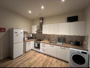a kitchen with white cabinets and a white refrigerator at Charming 2-Bedrooms City Centre Apartment-No Party in Aberdeen
