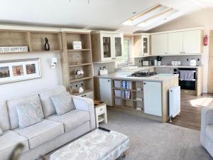 a living room with a couch and a kitchen at Vogue at Primrose in Reighton