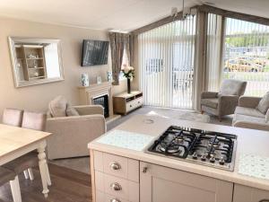 a kitchen and living room with a stove top at Vogue at Primrose in Reighton +6 photos