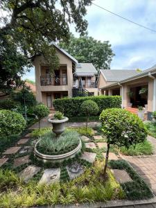 a house with a fountain in the middle of a garden at Del Roza Guest House in Middelburg
