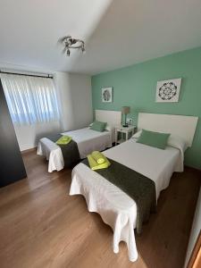 RosalにあるCasa A Cumieiraの緑の壁の部屋にベッドが2つある