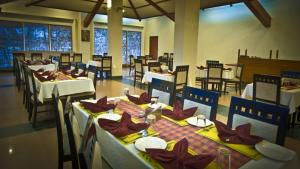 un comedor con mesas, sillas y mesa en Nala Hotels en Nāmakkal