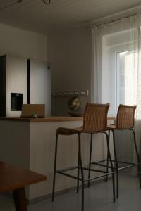 two chairs sitting at a counter in a kitchen at Ferienwohnung Ilse im Haus Namenlos in Baruth +6 photos