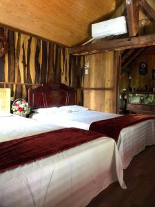 zwei Betten in einem Zimmer mit Holzwänden in der Unterkunft homestay nhà sàn in Buôn Alê (1)