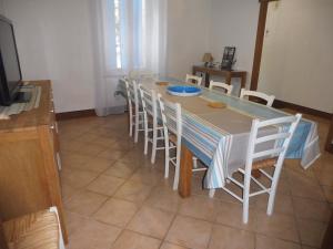 a dining room table with white chairs and a blue plate on it at Le Numéro 4 ! in Labruguière