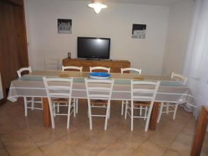a dining room with a table and chairs and a tv at Le Numéro 4 ! in Labruguière