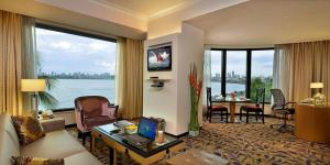 a living room with a couch and a table with a laptop at Hotel Marine Plaza in Mumbai