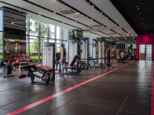 a gym with chairs and people exercising in it at Star KLCC Twin Tower Cozy 2-3pax by DingDing in Kuala Lumpur