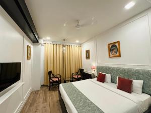 a hotel room with a bed and a tv at Hotel Atulyaa Taj in Agra