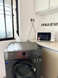 a washing machine in a kitchen with a microwave at Central Georgetown Cozy Hideaway, Penang in George Town +18 photos
