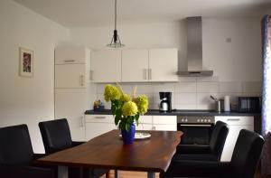 eine Küche mit einem Tisch, auf dem eine Blumenvase steht in der Unterkunft Ilonas Ferienwohnung in Sankt Aldegund