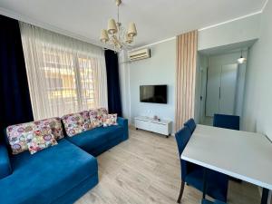 Una sala de estar con un sofá azul y una mesa. en MareBlu Summerland Mamaia, en Mamaia