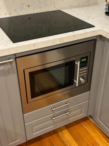 a microwave oven in a kitchen with a counter top at Regents Gate East Melbourne in Melbourne