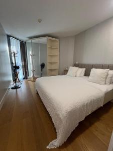 Un dormitorio con una cama grande con sábanas blancas. en Lovely Two Bedroom Appartment Istanbul, en Estambul