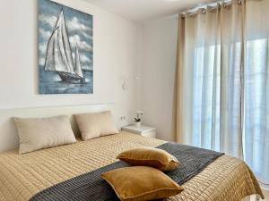 a bedroom with a bed with a sailboat painting on the wall at Luxury Apartment Tenerife in Adeje +10 photos